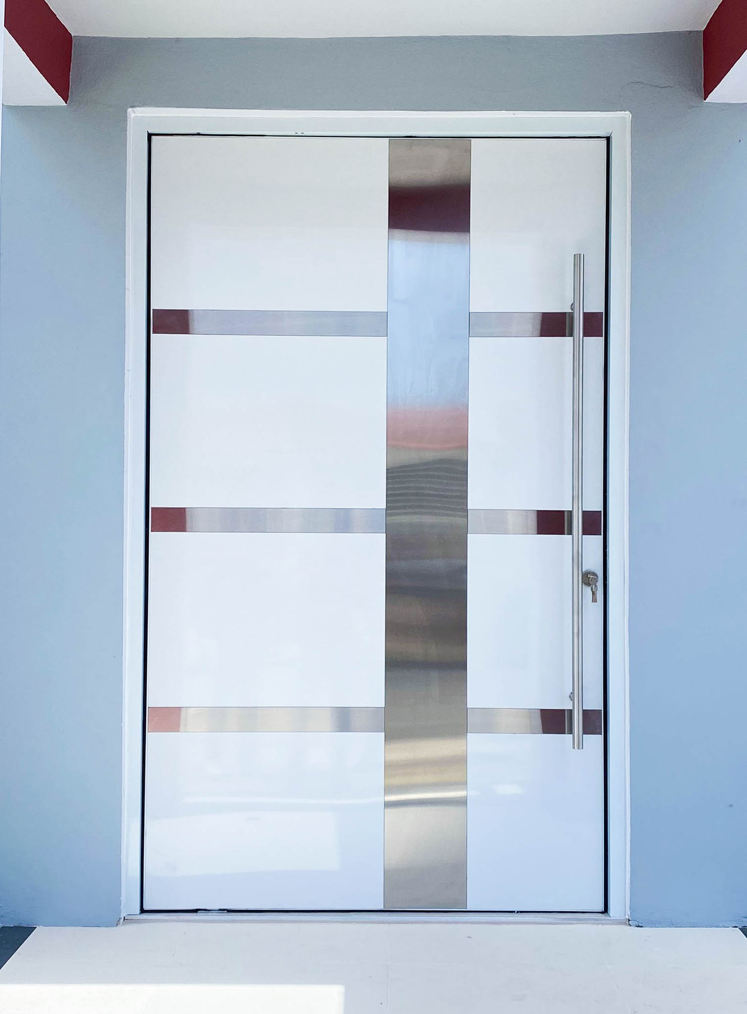 Puerta blanca con bandas de cristal instalada en fachada