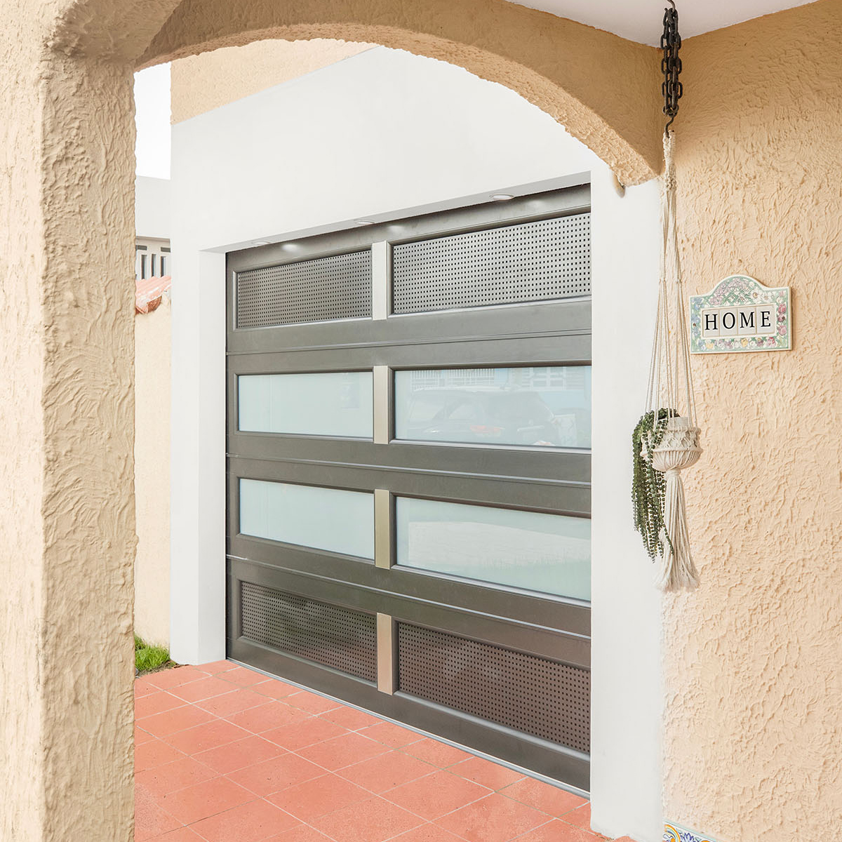 Puerta de garaje gris instalada bajo arco residencial